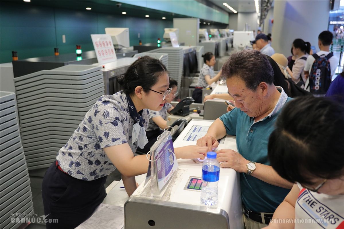 東航地面服務(wù)人員正在值機(jī)柜臺向旅客解釋航班情況。