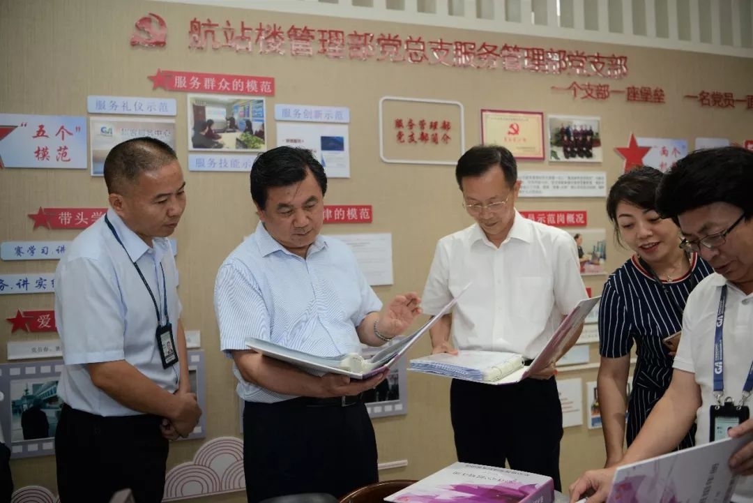 馮正霖觀摩重慶江北機場地服“心連心”班組建設(shè)材料。 中國民航報 陸二佳攝