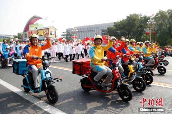 10月1日上午，慶祝中華人民共和國成立70周年大會在北京天安門廣場隆重舉行。圖為群眾游行中的“快遞小哥”。中新社記者 韓海丹 攝