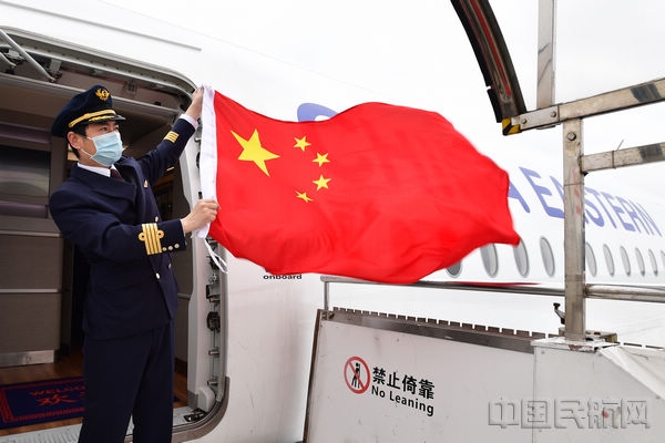 東航機組揮舞國旗，迎接我國首批援外抗疫專家組從浦東機場登機啟程前往意大利（本文圖片由東航提供）